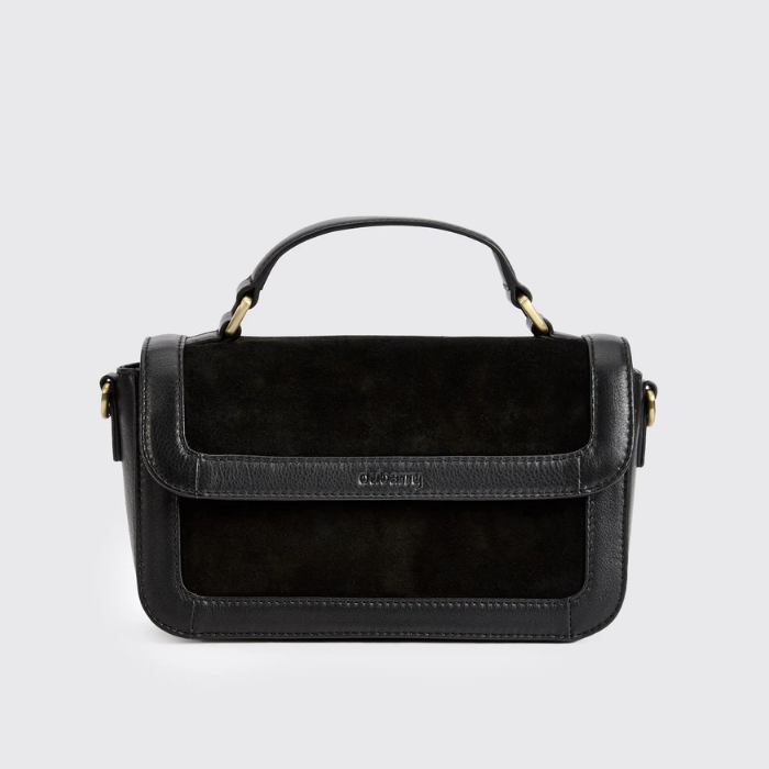 black leather and suede boxy handbag against a grey background