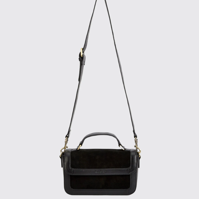 black leather and suede boxy handbag against a grey background