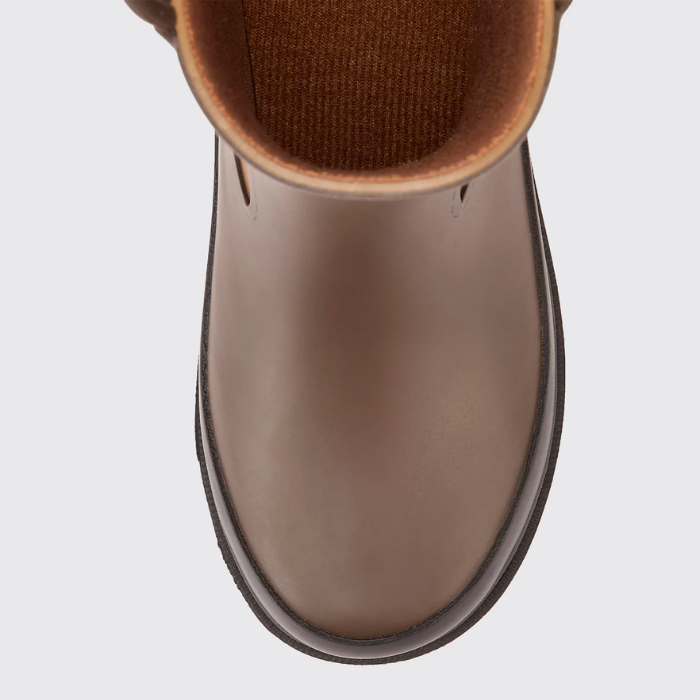 Close up of a brown boot on a light grey background