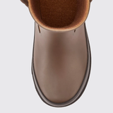 Close up of a brown boot on a light grey background