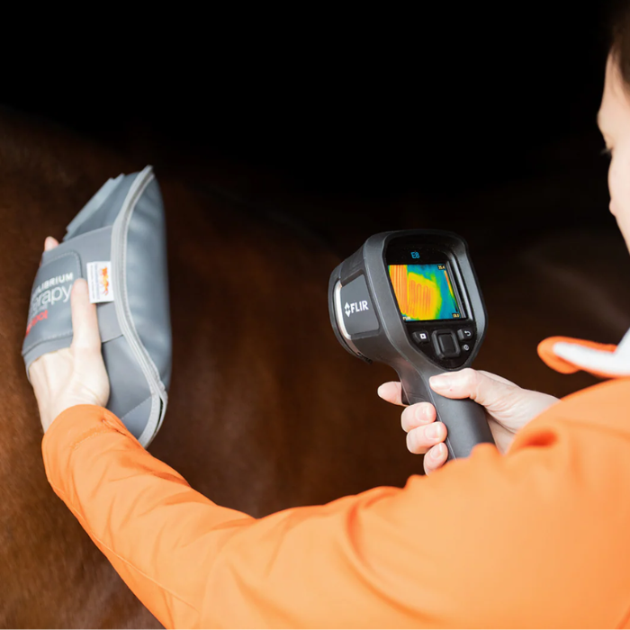 Person using a thermal imaging camera on a dark surface