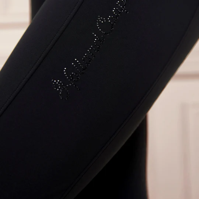 Black riding leggings with decorative Holland Cooper wording on a neutral background