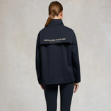Person wearing a navy jacket with 'Holland Cooper' branding on the back against a neutral background