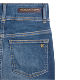 Close-up of blue denim jeans with a Holland Cooper label on a white background