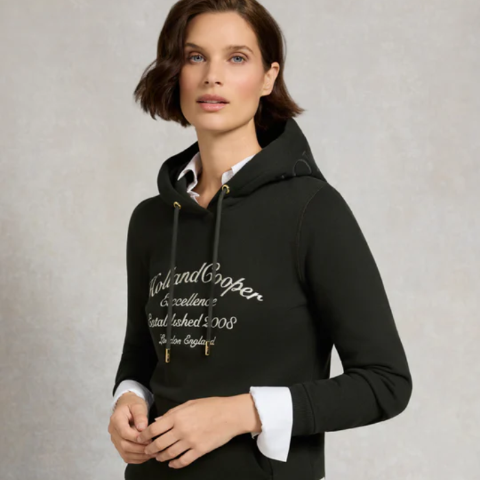 Woman wearing a dark green hoodie with text on a light grey background