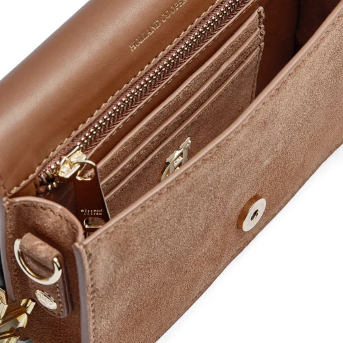 Close-up of a brown leather handbag with visible brand name.