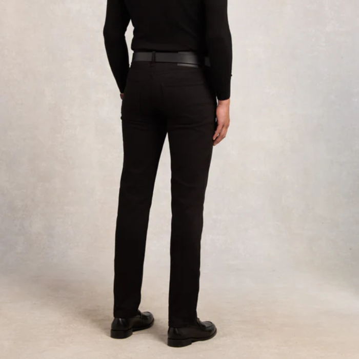 Person wearing black jeans and shoes on a plain background