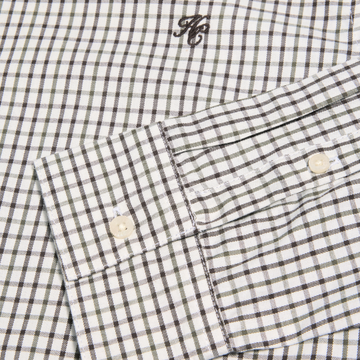 Close-up of a checkered shirt with a brand logo on a white background