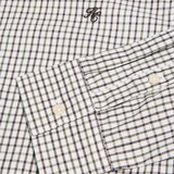 Close-up of a checkered shirt with a brand logo on a white background