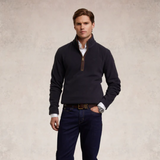 Man wearing a navy fleece and trousers against a beige background