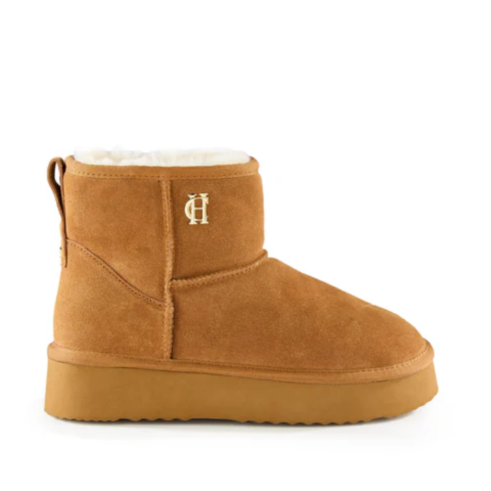 Tan suede boot with white fur lining on a white background