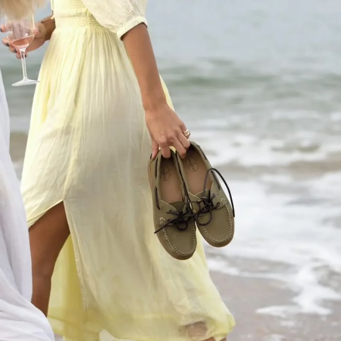 Woman on the beach clutches a pair of the Le Chameau Ladies Galion Femme Shoe in Vert Vierzon