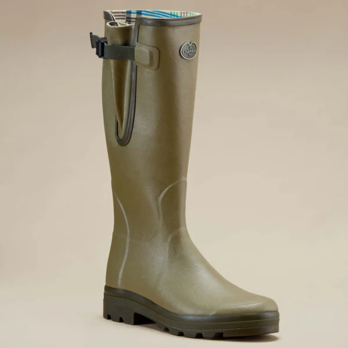 Green rubber boot on a beige background