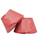 Pair of cranberry protective equestrian hoof boots on a white background
