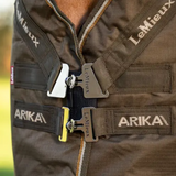 Brown equestrian rug with 'LeMieux' and 'Arika' branding on a blurred background