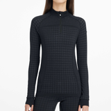 Black textured long-sleeve top worn by a person on a white background