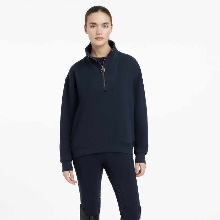 Person wearing a navy blue pullover with a zipper on a white background