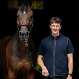 Man standing next to a horse on a dark background