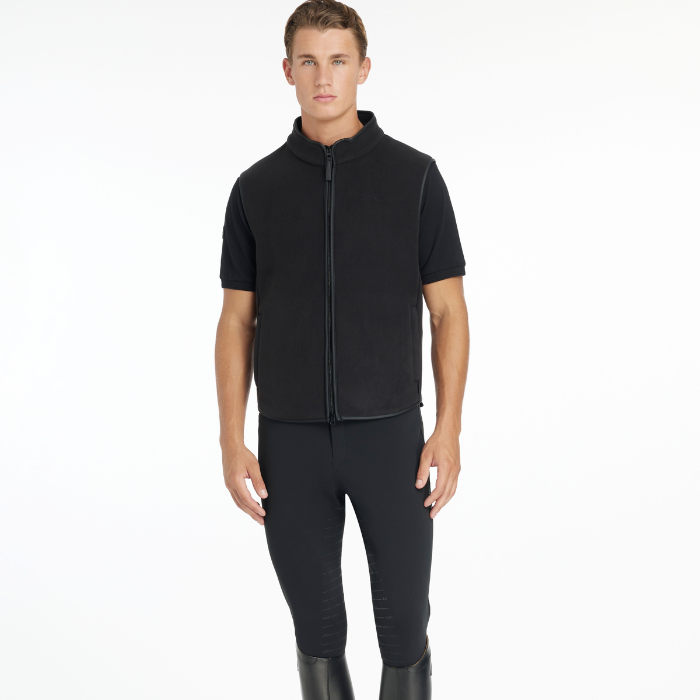 Man wearing a black gilet and black breeches on a white background