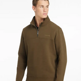 Person wears green quarter zip sweater with LeMieux branding on chest
