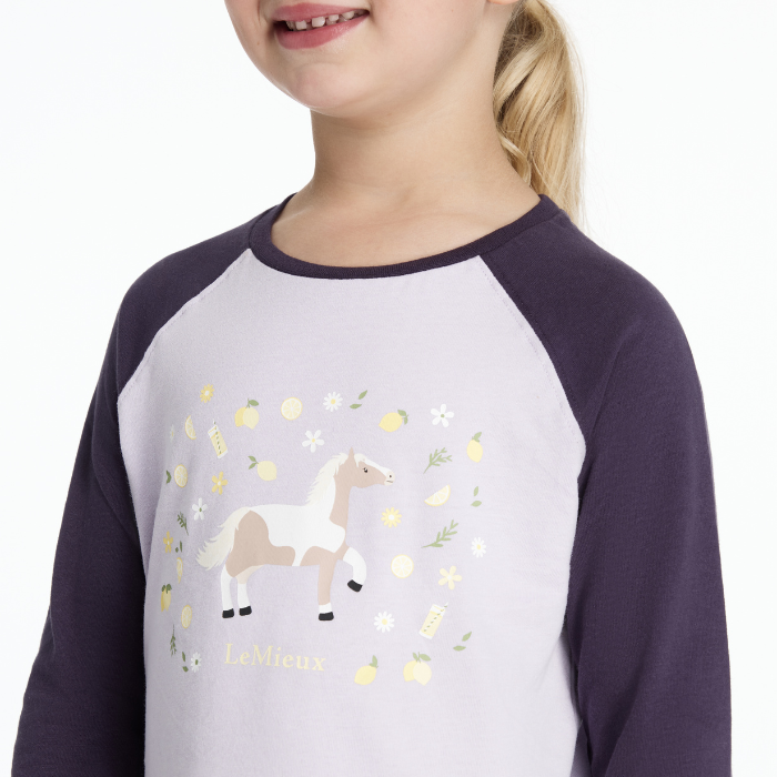 Child wearing a shirt with a horse design on a white background