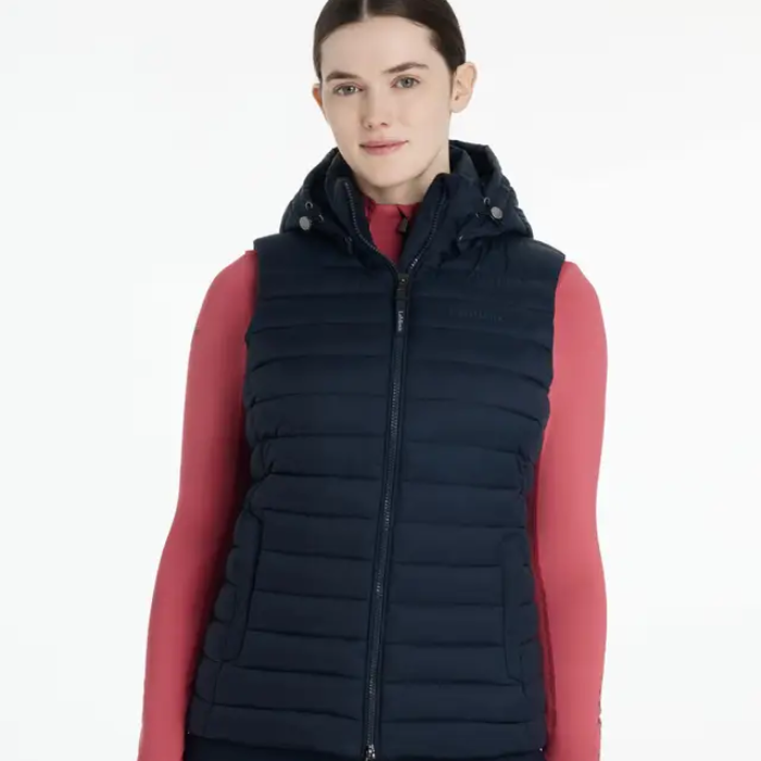 Person wearing a navy puffer gilet over a red base layer on a white background