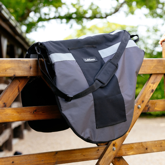 LeMieux Saddle Carry Bag in Black rests on fence