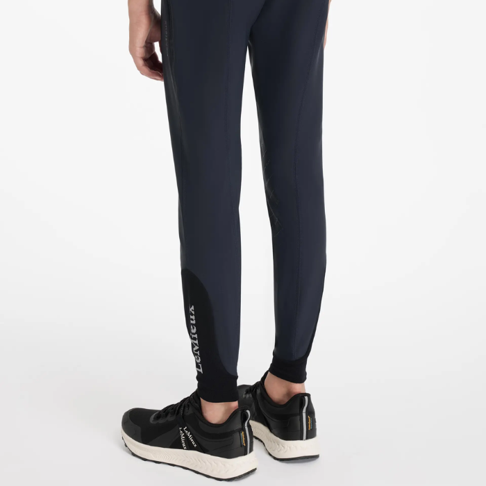 Person wearing black riding leggings with 'LeMieux' text on a white background