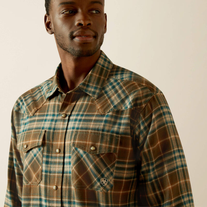 Man wearing a plaid shirt with a neutral background