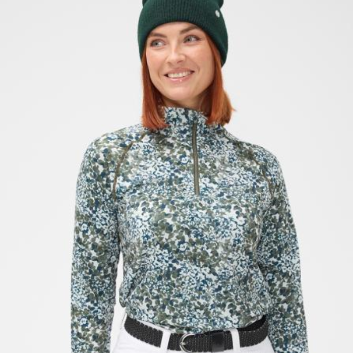 Woman wearing a patterned base layer and green beanie on a white background