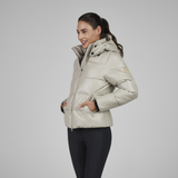 Woman wearing a beige puffer jacket on a grey background