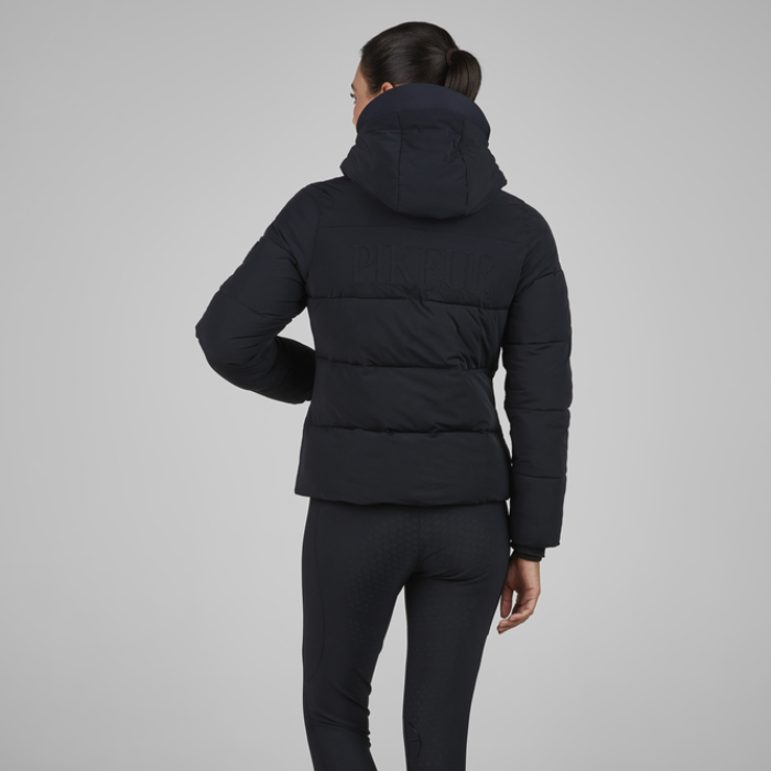 Person wearing a black puffer jacket on a grey background