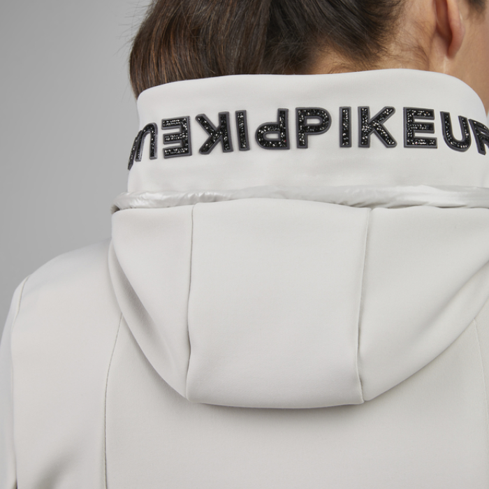 Close-up of a light grey hooded jacket with 'Pikeur' branding on a neutral background