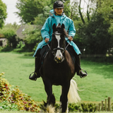 Rider on horse wears the Reincoat Adults PRO in Teal
