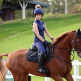Rider wears the Shires Aubrion Team Sleeveless Base Layer in Midlnight