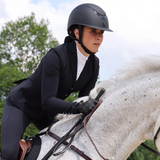 Rider wears the Shires Karben Elisa Ellipse Wide Peak Riding Hat in Black/Black