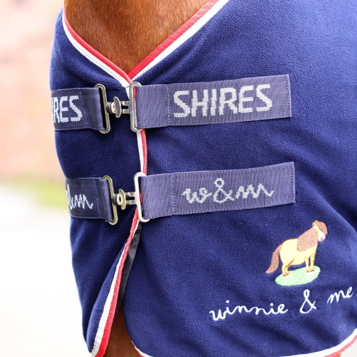 Navy blue equestrian rug with 'Shires' branding and 'Winnie & Me' embroidery.