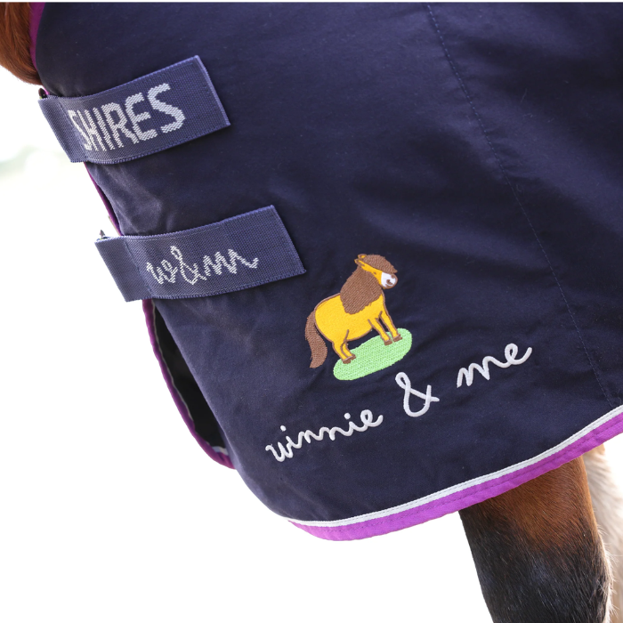 Navy horse blanket with 'Shires' branding and a cartoon horse design on a white background
