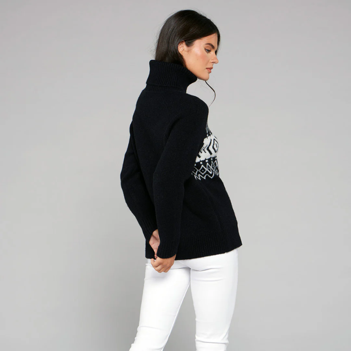 Woman wears a black jumper with a white pattern on the front