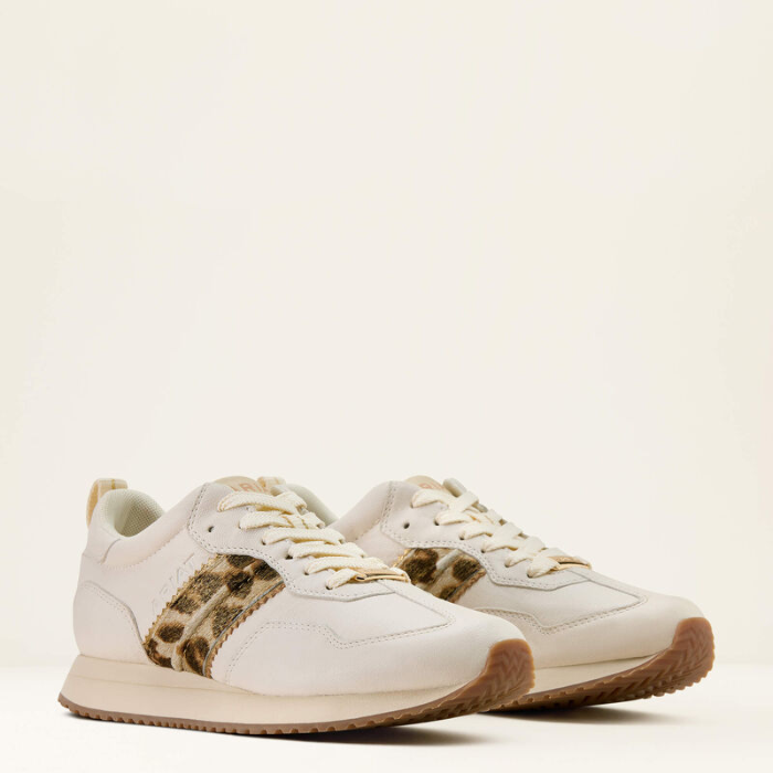 White sneakers with brown accents on a light beige background