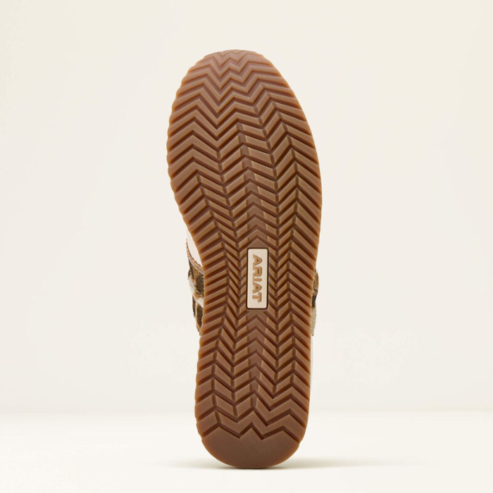 Close-up of a brown shoe sole with a brand logo on a beige background