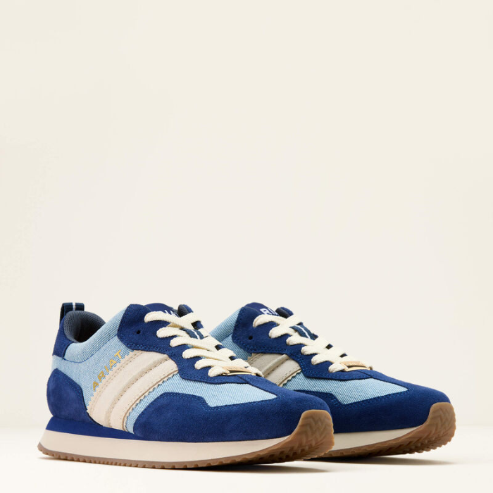 Blue and light blue trainers with white laces on a beige background