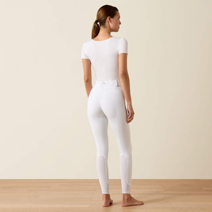 Person wears white riding breeches on a beige background