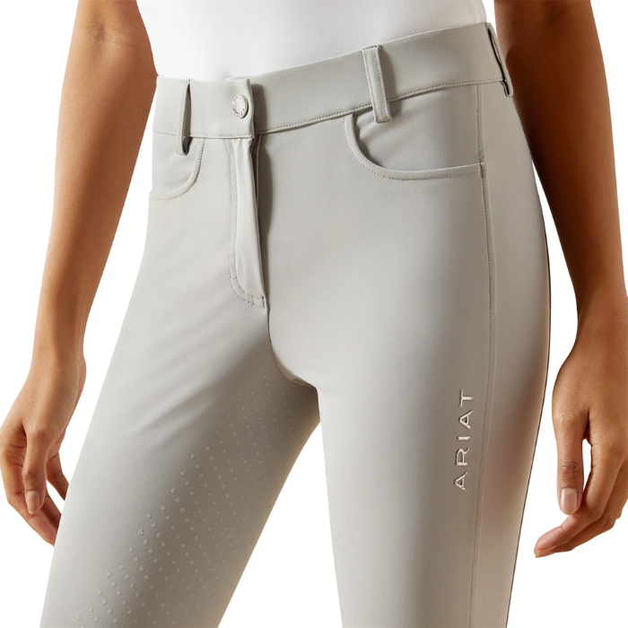Light gray riding pants with 'Ariat' branding on a white background
