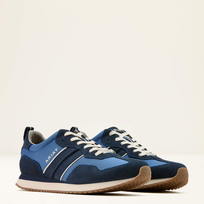 Blue trainers with white laces on a light beige background
