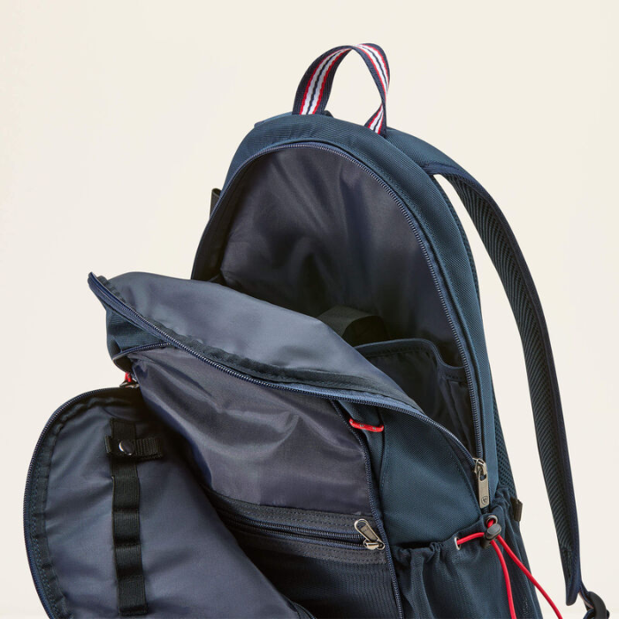 Open navy blue backpack with red and white straps on a beige background