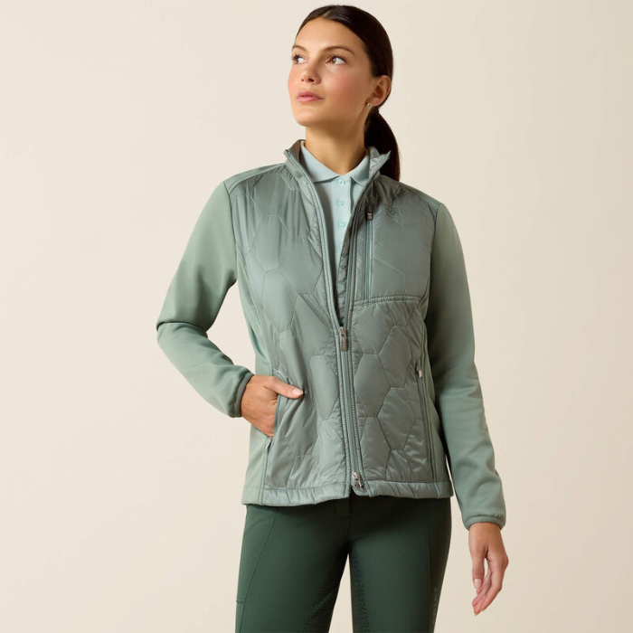 Woman wearing a light green quilted jacket on a beige background