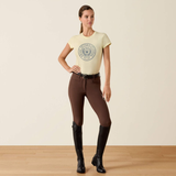 Woman wears a yellow t-shirt and brown leggings on a beige background