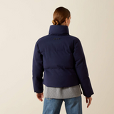 Person wearing a navy blue jacket on a beige background