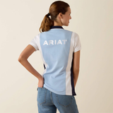 Woman wears a blue and white polo shirt with ARIAT logo on a plain background
